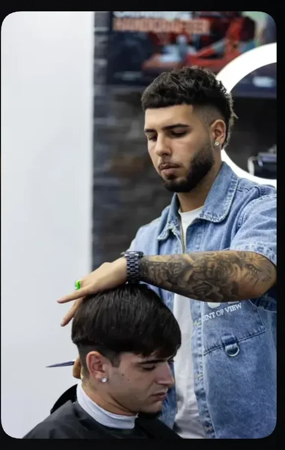 Barbeiro finalizando o corte de um cliente na São Francisco